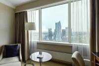 a hotel room with a table and a chair and a large window at Warsaw Presidential Hotel in Warsaw