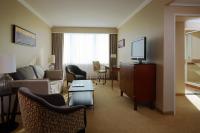 a living room with a couch and a tv at Warsaw Presidential Hotel in Warsaw