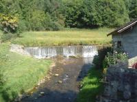 a waterfall in a field next to a river at GITE LES 3 EDELWEISS - Maison SEGUITTE - 6 PERSONNES in Arette