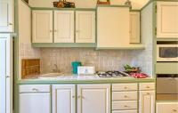 a kitchen with green and white cabinets and a sink at Cozy Apartment In Saint Jean Du Bruel With Private Swimming Pool, Can Be Inside Or Outside in Saint-Jean-du-Bruel