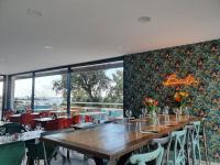 ein Restaurant mit Tischen und Stühlen und einem großen Fenster in der Unterkunft Blue Horizon in Saint-Raphaël