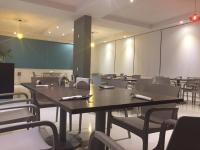 una sala de conferencias con mesas, sillas y una pantalla en Hotel Verdi, en San Juan Bautista Tuxtepec