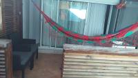 a hammock in a room with a table and chairs at Gabi hostel in Cayenne