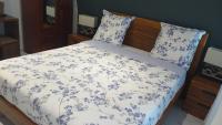 a bed with blue and white sheets and pillows at Gabi hostel in Cayenne