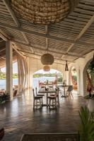a pavilion with a table and chairs and water at Casa na Lagoa in Paracuru