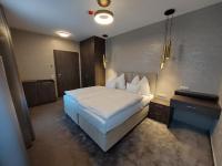 Łóżko lub łóżka w pokoju w obiekcie Hotel Szatmári & Étterem Jászberény
