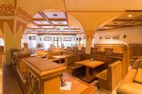 un restaurante con mesas de madera y bancos en una habitación en Alpenrast Tyrol, en Mils bei Imst