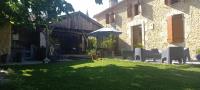 a yard with some white chairs and an umbrella at La Métairie du Clos Saint Louis in Montréal