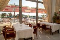 a restaurant with white tables and chairs and a large window at Grand Hotel Ontur Cesme in Cesme