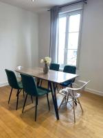 a dining room table with green chairs and a vase of flowers at En_Terre_Champenoise Epernay in Épernay