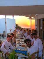 a group of people sitting at a long table at Mourtzanakis Residence - Traditional Eco Hotel in Achlada in Achlada