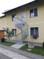 a yellow house with a spiral staircase in front of it at Ferienwohnung Heimberger in Purgstall