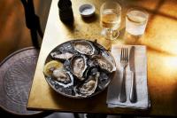 a plate of oysters on a table with a glass of beer at No 42 by GuestHouse, Margate in Margate
