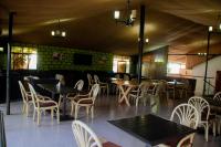 ein Restaurant mit Tischen und Stühlen in einem Raum in der Unterkunft Distinction Gardens in Siaya