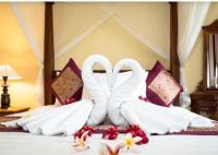 Una cama con dos cisnes hechos de toallas. en Buana Ubud Inn, en Ubud