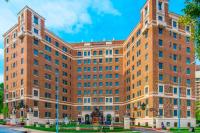 a large brick building with two towers on a street at The Raphael Hotel, Autograph Collection in Kansas City