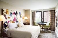 a hotel room with a bed and a table and chairs at The Raphael Hotel, Autograph Collection in Kansas City