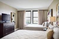 a hotel room with two beds and a flat screen tv at The Raphael Hotel, Autograph Collection in Kansas City