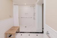 a white bathroom with a shower and a bench at The Raphael Hotel, Autograph Collection in Kansas City