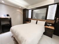 a bedroom with a large white bed and a window at Guide Hotel Taipei Xinyi in Taipei