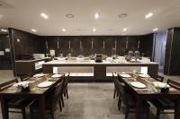 uma sala de jantar com mesas e cadeiras e uma cozinha em Best Western Plus Jeonju em Jeonju