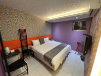 a bedroom with a bed and a purple wall at Boston Hotel in Chiayi City