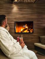 a man and a woman sitting in front of a fireplace at Heide Spa Hotel &amp; Resort in Bad Düben