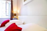 two white beds with red pillows in a bedroom at Sainte Catherine - Duplex 1 chambre in Bordeaux