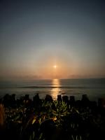 a sunset over the ocean with a rocky shore at Bridge12th B&amp;B in Yanliau