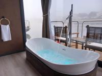 a bath tub in a room with a view at L&#39;Escale Royale L&#39;Isle Adam à 20 minutes de Paris CDG in LʼIsle-Adam