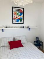 a bedroom with a white bed with a red pillow at Charmant Appartement Pop - Arty in Thonon-les-Bains