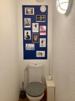 a bathroom with a toilet and pictures on the wall at Charmant Appartement Pop - Arty in Thonon-les-Bains