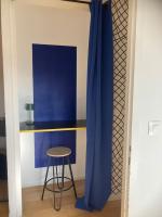 a room with a stool and a blue curtain at Charmant Appartement Pop - Arty in Thonon-les-Bains