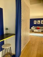 a living room with a blue curtain and a stool at Charmant Appartement Pop - Arty in Thonon-les-Bains