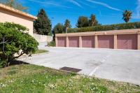 a parking lot in front of a building with two garage doors at Les Jardins de Provence • Beau Rivage • Proche mer in Carqueiranne