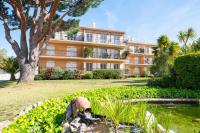 a large orange building with a tree and a pond at Les Jardins de Provence • Beau Rivage • Proche mer in Carqueiranne