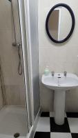 a bathroom with a sink and a shower with a mirror at Pensión San Benito Abad in Seville