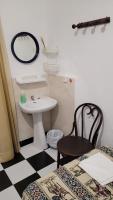 a bathroom with a sink and a table and a chair at Pensión San Benito Abad in Seville
