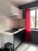 a kitchen with a sink and a red curtain at Petit appartement centre ville Granville in Granville