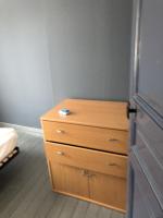 a bedroom with a wooden dresser and a drawer at Petit appartement centre ville Granville in Granville