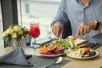 a person eating food on a table with plates of food at Grand Ocean Luxury Boutique - Infinity Rooftop Pool in Da Nang