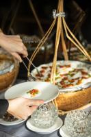 a person holding a plate with a pizza on a table at Grand Ocean Luxury Boutique - Infinity Rooftop Pool in Da Nang