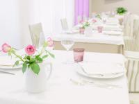 uma mesa branca com pratos brancos e flores em Hotel Sporting em San Benedetto del Tronto