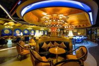 ダラットにあるMercure Dalat Resortのテーブルと椅子とシャンデリアのあるレストラン