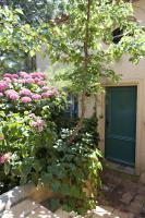 a building with a green door and pink roses at Saint-Vincent in Saint-Tropez