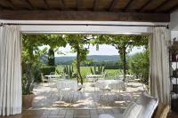 a patio with white tables and chairs and trees at Saint-Vincent in Saint-Tropez