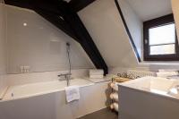 a bathroom with a bath tub and a sink at Hotel Restaurant Le Maréchal - Teritoria in Colmar
