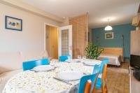 a dining room with a table and blue chairs at Ty Menez - Proche plage pour 4 in Bénodet