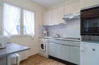 a kitchen with white cabinets and a washer and dryer at Ty Menez - Proche plage pour 4 in Bénodet