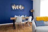 Un comedor con una mesa y una pared azul. en Appartement spacieux, en Quimper